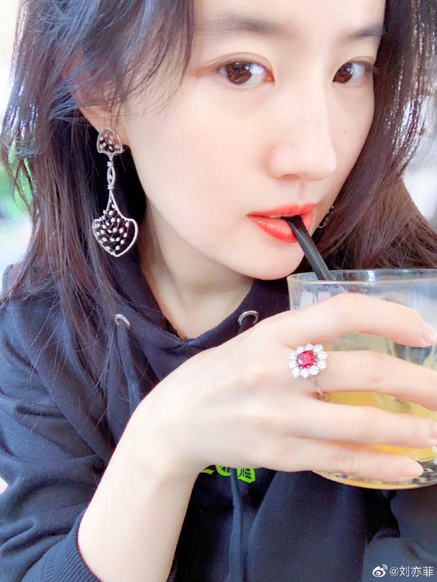 照片中,刘亦菲捧着一杯饮料正在喝,红唇白肤,长发微卷,轻咬吸管,大眼