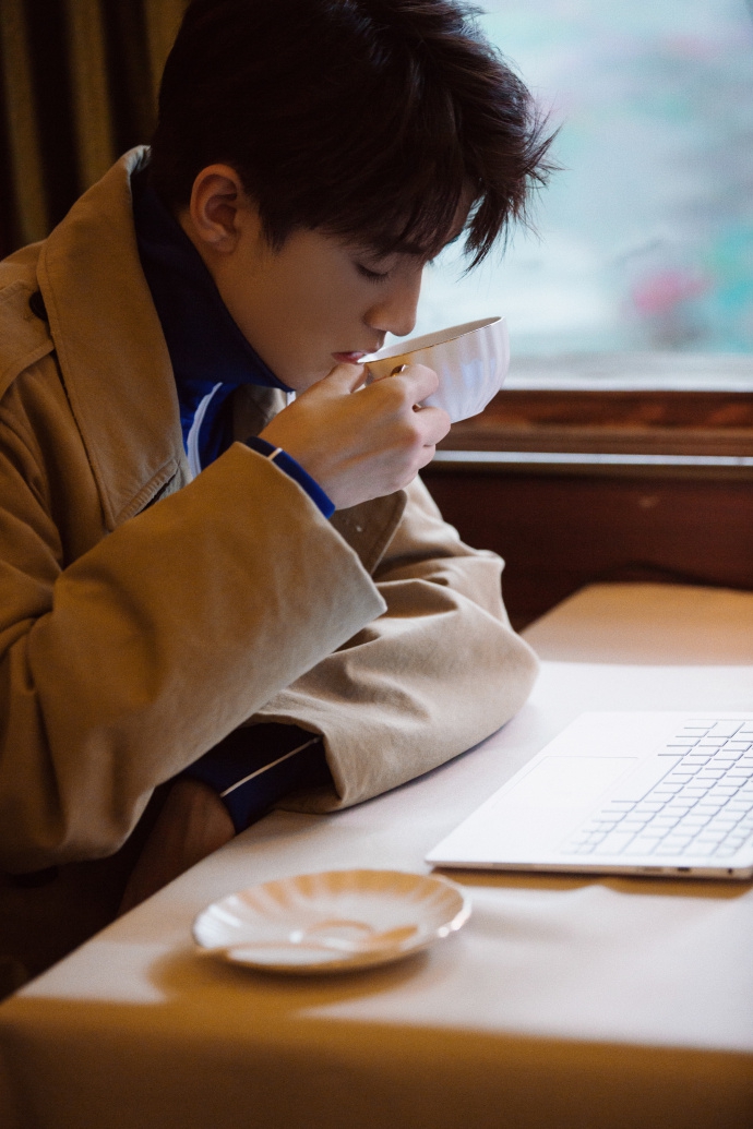 侧颜杀!王俊凯喝咖啡神情专注 外披风衣职场范儿足