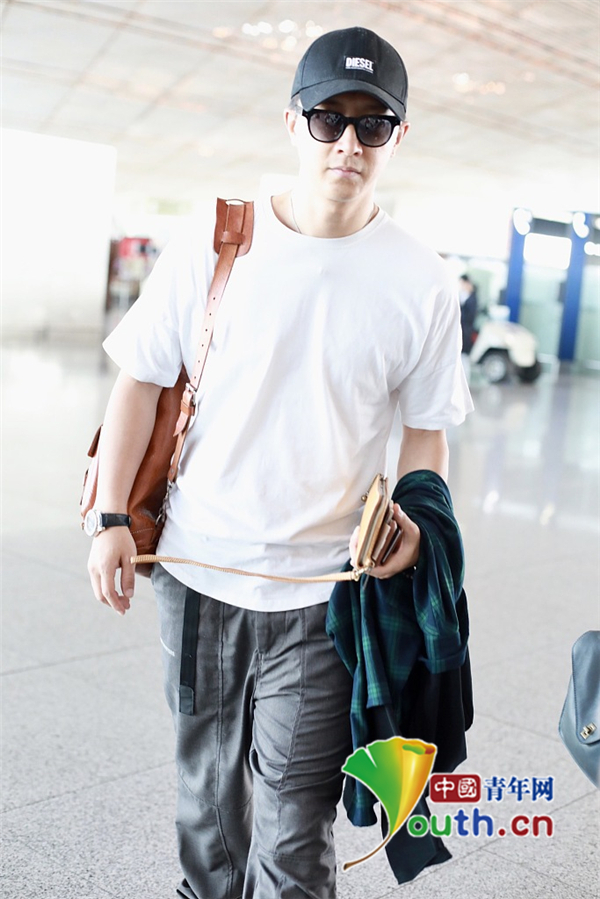 韩庚戴棒球帽穿白t恤现身机场自背大包一路快走